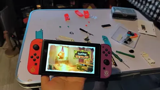 Switch avec Joy-Con orange et violet, allumée